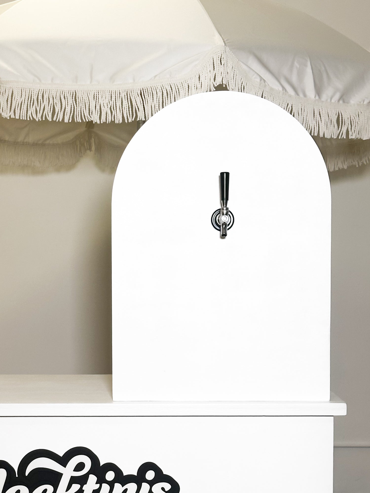 Small arch wall with tap handle on a table.