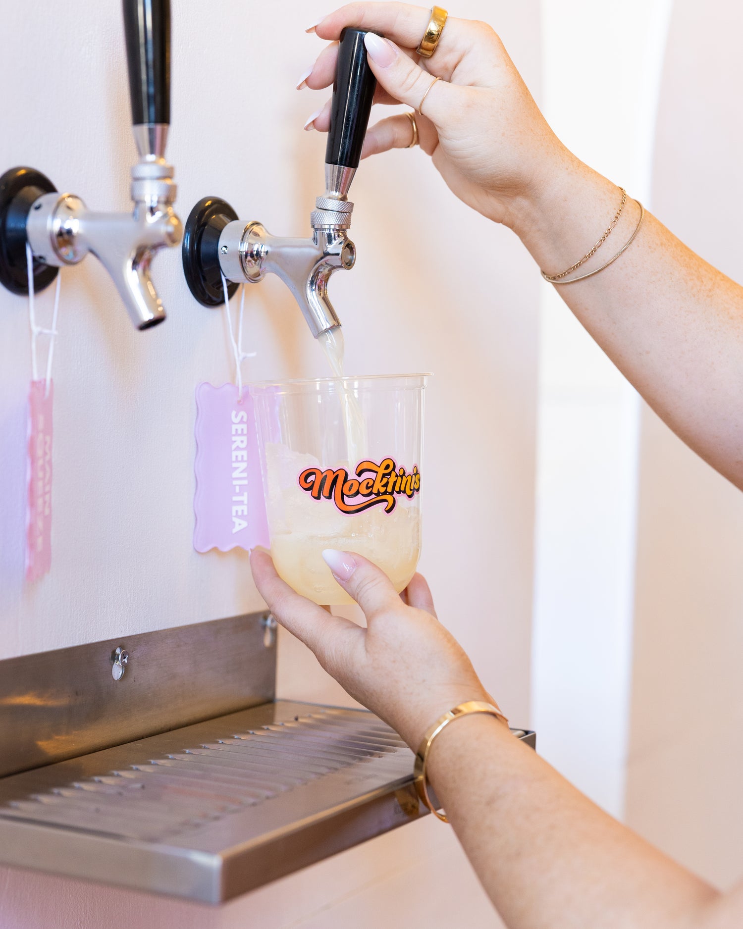 Person pouring a drink from a tap into a cup